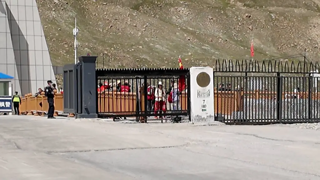 Chinese visitors with flags behind the fence at Khunjerab zero point